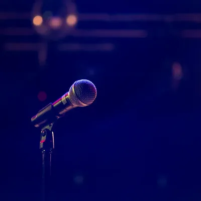 A microphone on a stand under deep blue stage light