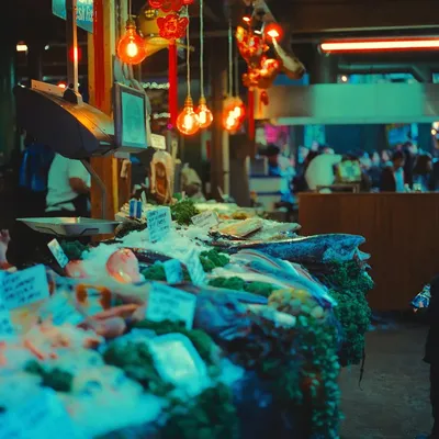 A market stall of goods under hanging lamps